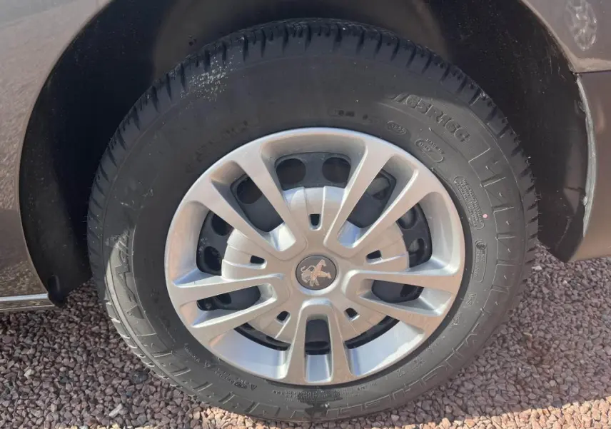 Gros plan sur la roue avant droite du Peugeot Expert Fourgon gris platinium, avec jante en alliage et logo lion central.