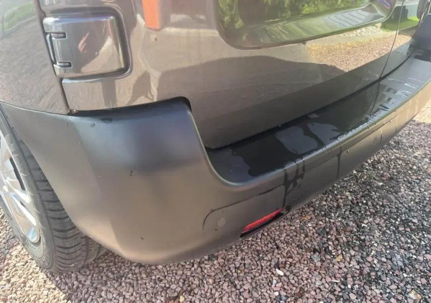 Gros plan sur le pare-chocs arrière gris platinium métallisé du Peugeot Expert Fourgon, avec capteur de stationnement visible.