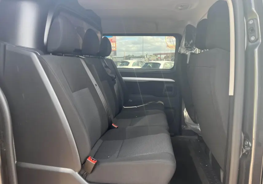 Banquette arrière noire vue de côté gauche dans le Peugeot Expert Fourgon gris platinium 2023 cabine approfondie.