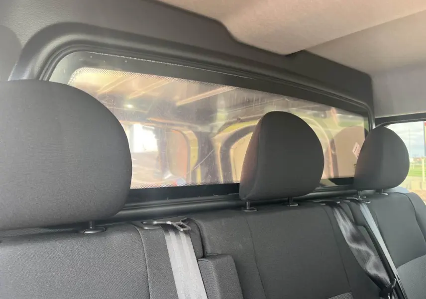 Banquette arrière noire avec appuie-têtes et cloison plexiglass du Peugeot Expert Fourgon gris platinium 2023.