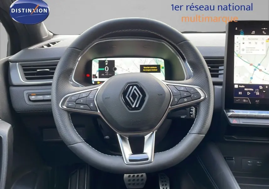 Vue centrée sur le volant noir perforé du Renault Captur E-Tech 2025 avec tableau de bord numérique et écran tactile.