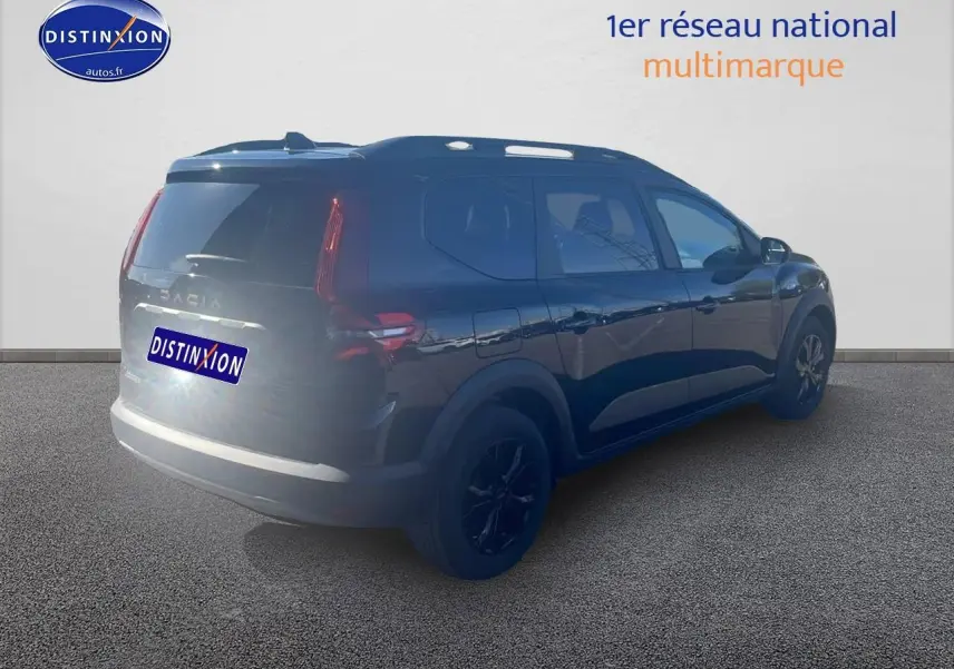 Vue 3/4 arrière droite d'un Dacia Jogger noir nacré avec barres de toit et jantes alu noires.