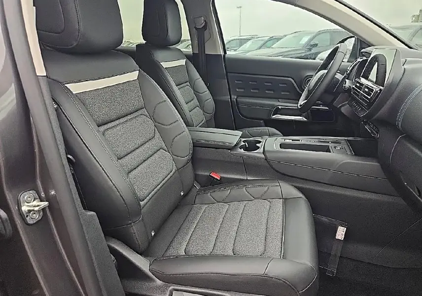 Vue intérieure côté conducteur du Citroën C5 Aircross gris 2025, sièges avant en cuir et tissu avec accoudoir central.