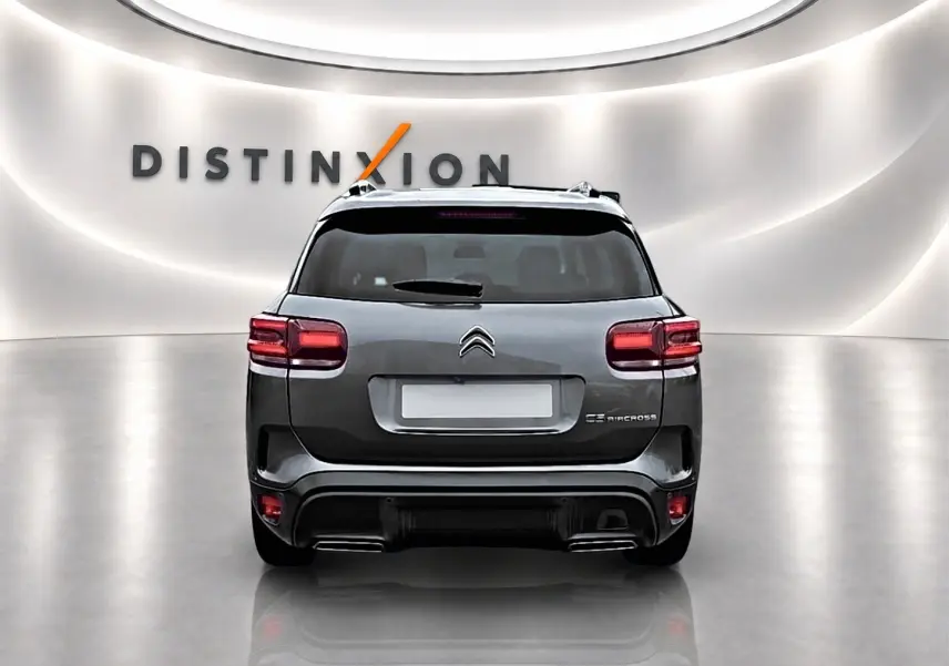 Vue arrière d'un Citroën C5 Aircross gris 2025 avec feux LED et barres de toit dans un showroom lumineux.