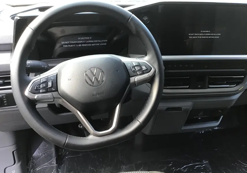 Vue rapprochée du volant multifonction et du tableau de bord numérique du Volkswagen Transporter ProCab 2025, finition Business.