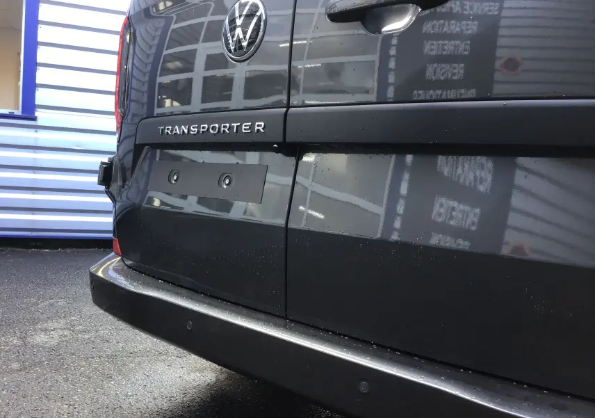 Gros plan sur l'arrière gris anthracite du Volkswagen Transporter ProCab 2025 avec logo VW et feux LED visibles.