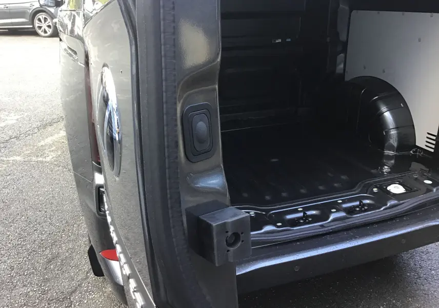 Vue partielle arrière droite du Volkswagen Transporter ProCab gris anthracite avec porte ouverte montrant le compartiment de charge vide.