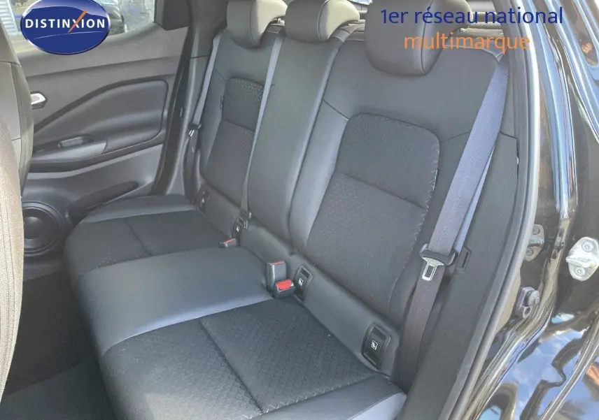 Vue intérieure sur les sièges arrière en cuir gris et tissu noir du Nissan Juke 2024, porte arrière droite ouverte.