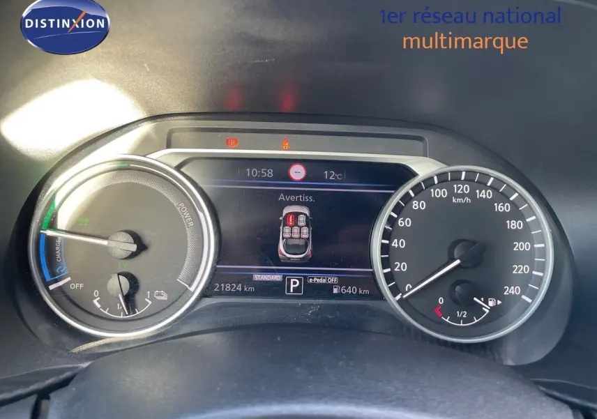 Tableau de bord du Nissan Juke 2024 hybride, affichage digital central et compteurs analogiques vitesse et puissance.