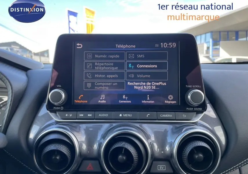 Écran tactile central du Nissan Juke 2024 affichant le menu téléphone, avec aérateurs ronds argentés en dessous.