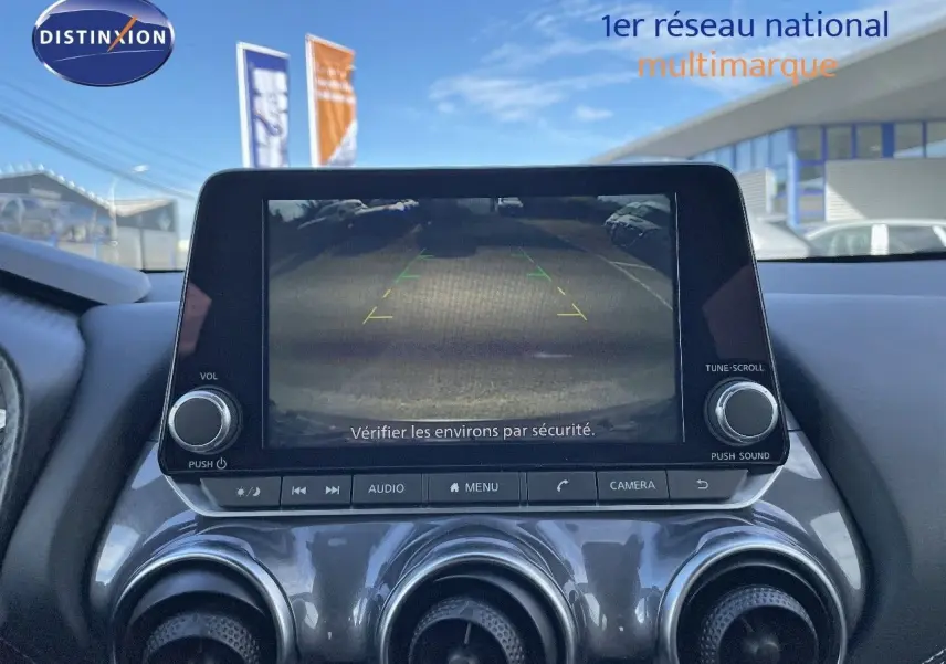 Écran central du Nissan Juke 2024 montrant la caméra de recul avec les commandes audio et climatisation en dessous.