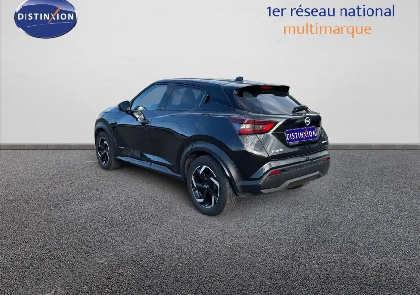 Nissan Juke noir métal vu en 3/4 arrière côté gauche, soulignant ses lignes modernes et ses jantes noires.