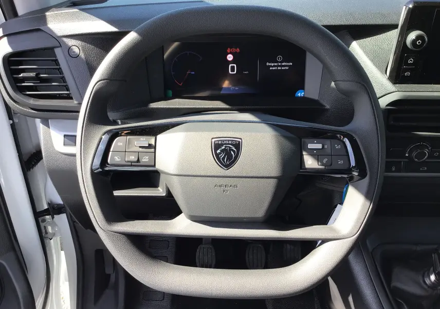 Vue rapprochée du volant et du tableau de bord du Peugeot Expert Fourgon blanc 2025 avec commandes intégrées et boîte manuelle.