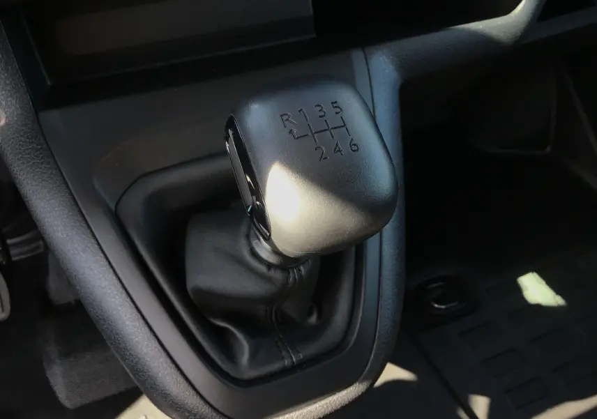 Le levier de vitesses manuel noir en gros plan dans l'habitacle du Peugeot Expert Fourgon blanc 2025.