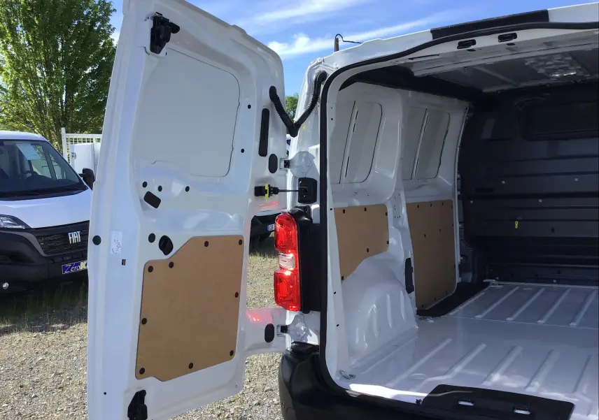 Vue arrière ouverte du Peugeot Expert Fourgon blanc 2025 montrant l'intérieur spacieux et les portes arrière battantes.