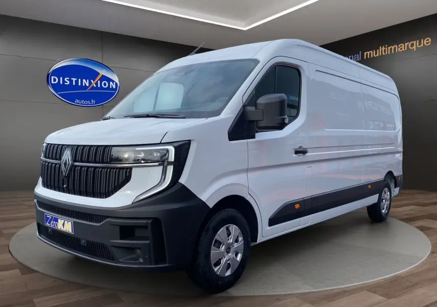 Renault Master blanc en 3/4 avant droit, avec calandre noire et jantes argentées, sur fond intérieur showroom.