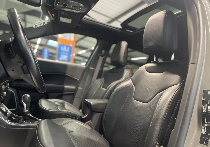 Intérieur Jeep Compass 2021, vue côté gauche sur sièges cuir noirs et toit ouvrant panoramique CommandView.