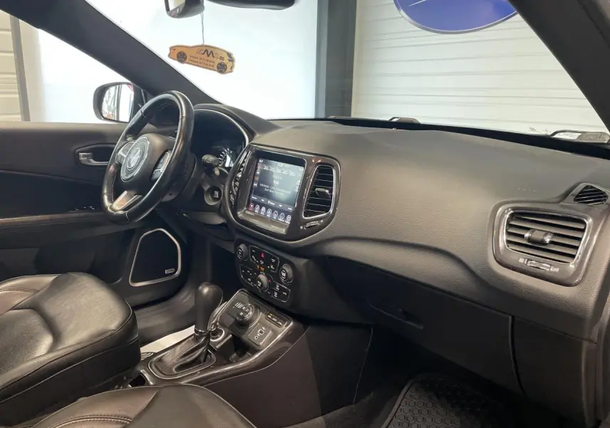 Intérieur noir cuir du Jeep Compass 2021, vue côté passager avec tableau de bord et écran tactile central.