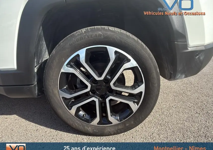 Gros plan sur la roue avant gauche du Jeep Compass blanc 2024 avec jante alliage 18 pouces au design moderne.