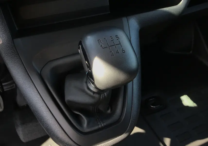 Gros plan sur le levier de vitesses manuel noir du Peugeot Expert Fourgon blanc 2025, version BlueHDi 120 Pack Connectivité.