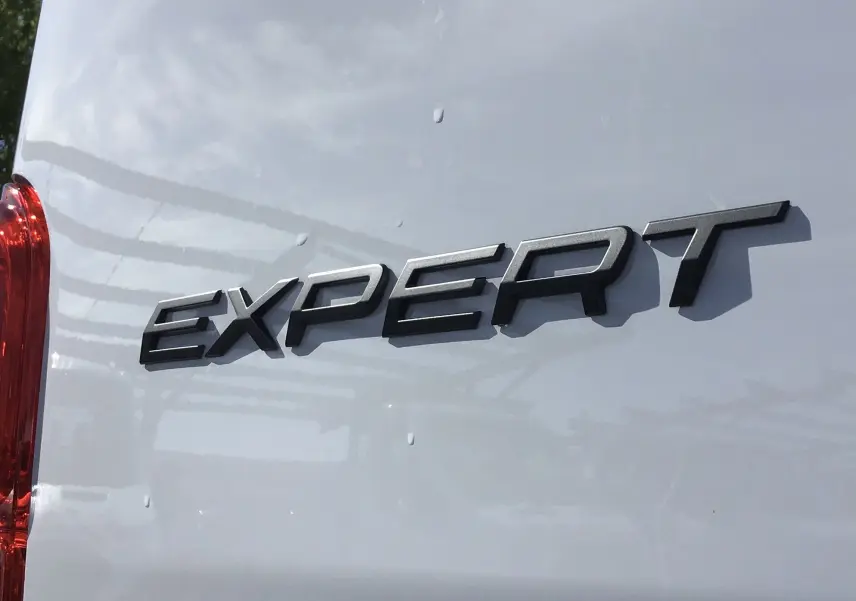 Gros plan sur l'arrière blanc du Peugeot Expert Fourgon avec le logo "EXPERT" en relief noir.