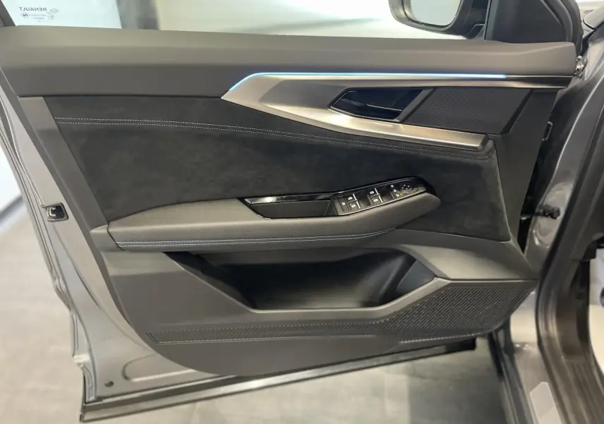 Intérieur côté gauche de la porte avant d'un Renault Austral 2025 gris métallisé avec garniture Alcantara noire et éclairage d'ambiance bleu.