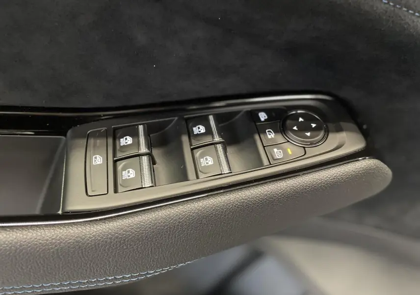 Commande des vitres et rétroviseurs côté conducteur du Renault Austral gris métallisé avec surpiqûres bleues sur la porte intérieure