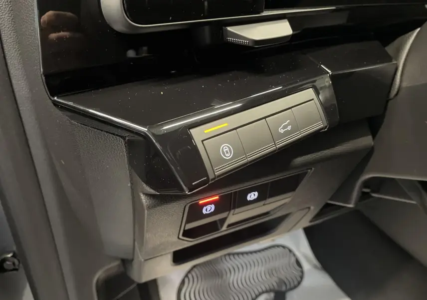 Gros plan sur la console centrale noire brillante du Renault Austral 2025, avec boutons de contrôle et éclairages LED.