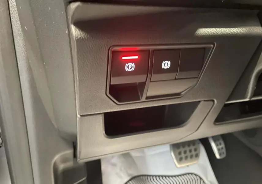 Gros plan sur les commandes du frein de parking électrique et arrêt auto, pédalier aluminium visible, intérieur Renault Austral 2025.