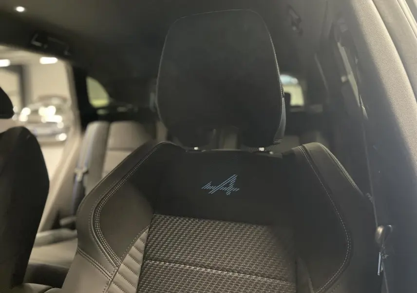 Gros plan sur le siège avant conducteur noir avec logo Esprit Alpine brodé bleu, intérieur du Renault Austral 2025.