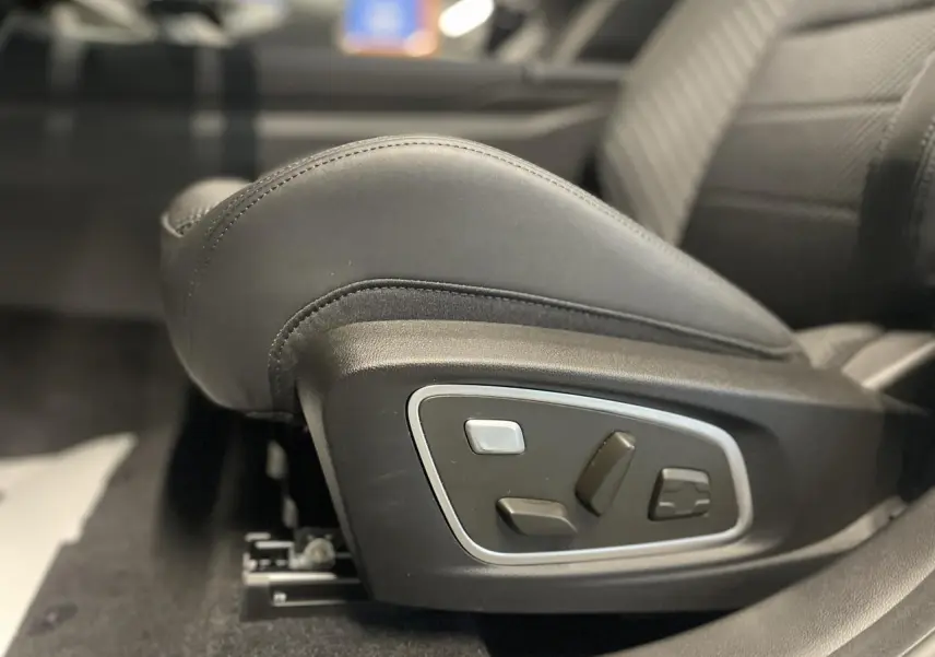 Réglages électriques du siège conducteur en cuir noir dans un Renault Austral gris métallisé, vue latérale intérieure.