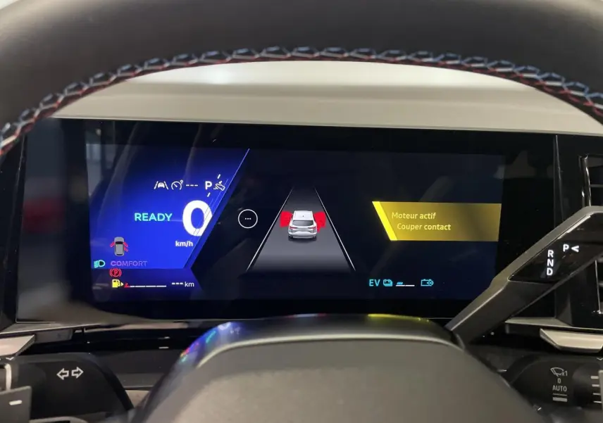 Tableau de bord numérique du Renault Austral 2025, affichage de conduite et aide à la sécurité en vue frontale.