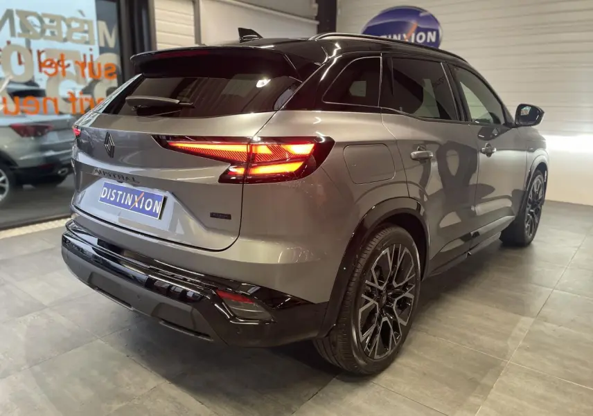 Vue 3/4 arrière droite du Renault Austral gris métallisé avec toit noir étoilé et jantes alliage noires.