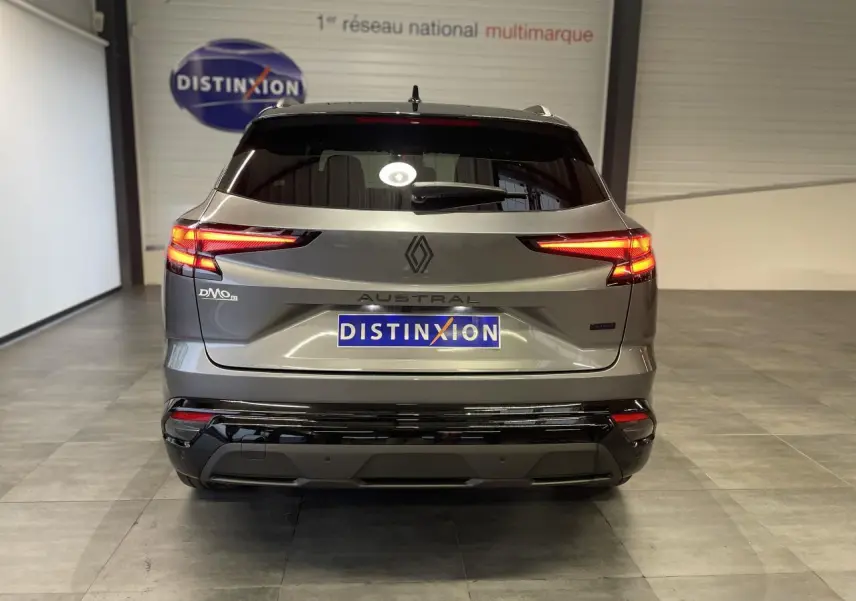 Vue arrière d'un Renault Austral gris métallisé avec feux LED allumés et logo distinctif au centre du hayon.