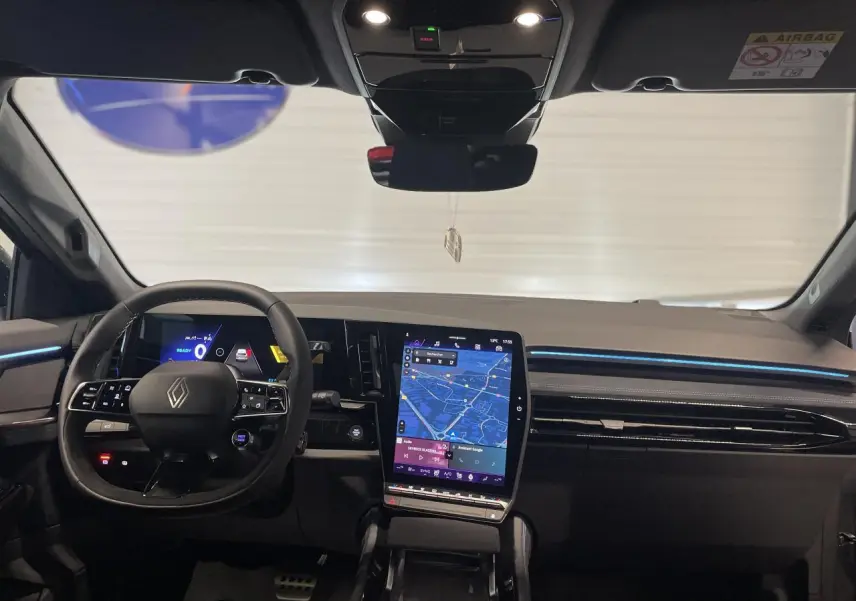 Intérieur du Renault Austral 2025, vue frontale du tableau de bord avec écran tactile vertical et volant multifonction noir.