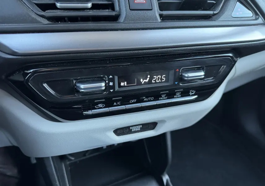 Gros plan sur la console centrale de la Suzuki Swift 2024, affichant la climatisation automatique à 20,5°C avec commandes tactiles noires et grises.
