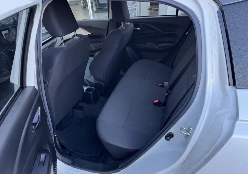 Vue intérieure côté gauche arrière d'une Suzuki Swift 2024 blanc/gris montrant les sièges arrière en tissu noir.