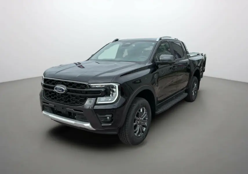 Ford Ranger 2.0 205 Wildtrak Plus noir agate en 3/4 avant droit avec jantes alu et barres de toit visibles.