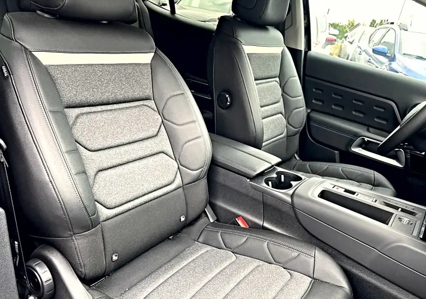 Vue intérieure rapprochée des sièges avant gris foncé et console centrale du Citroën C5 Aircross 2025.