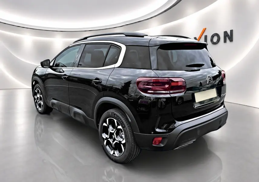 Citroën C5 Aircross noir vue 3/4 arrière droit, jantes alu et vitres arrière teintées dans un showroom lumineux.