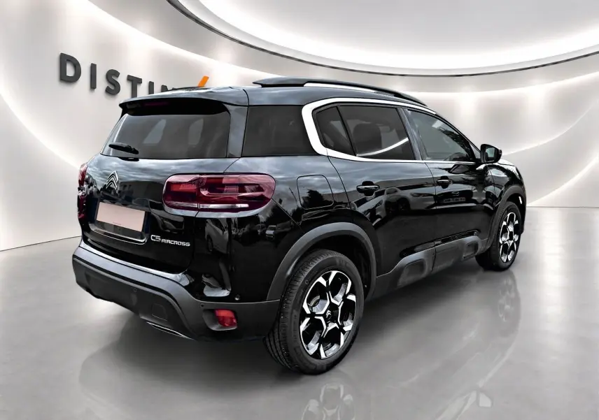 Vue 3/4 arrière droite du Citroën C5 Aircross noir brillant avec jantes alu et vitres arrière teintées.