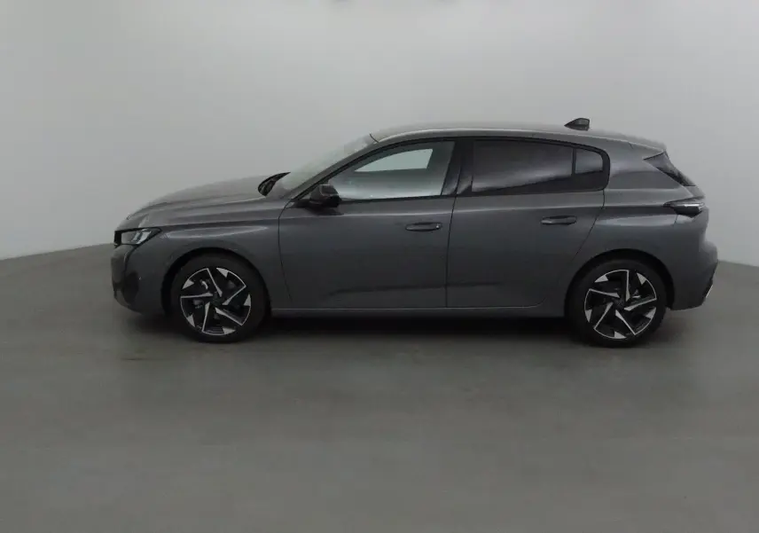 Profil côté gauche d'une Peugeot 308 gris sélénium avec jantes alliage et vitres teintées dans un studio blanc.