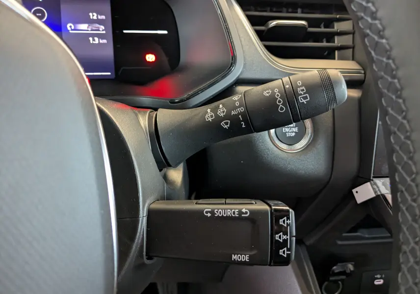 Gros plan sur la commande des essuie-glaces et du régulateur dans le tableau de bord du Renault Captur rouge flamme 2025.