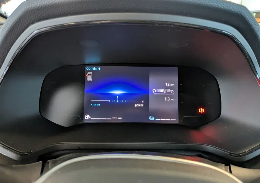 Tableau de bord numérique du Renault Captur E-Tech 2025 affichant mode confort et indicateurs de charge et puissance.