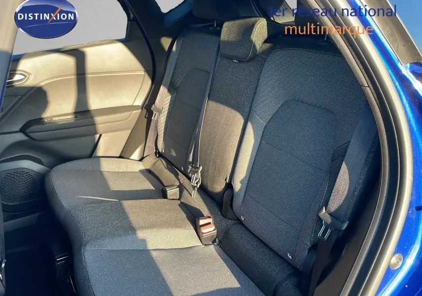 Vue latérale côté droit de l'habitacle arrière du Renault Captur bleu iron metal avec sièges tissu gris.