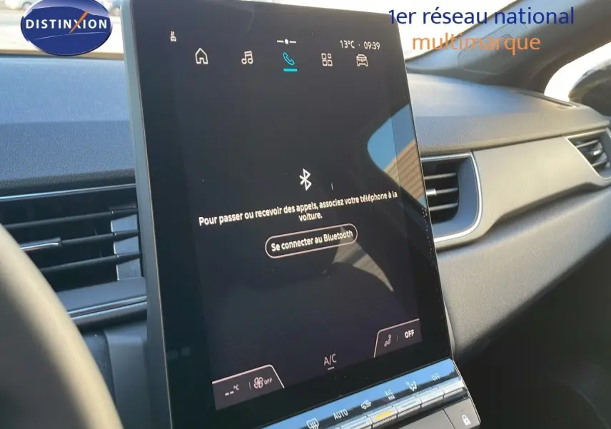 Écran tactile central allumé dans l'habitacle du Renault Captur E-Tech Hybrid 2025, ambiance intérieure moderne.