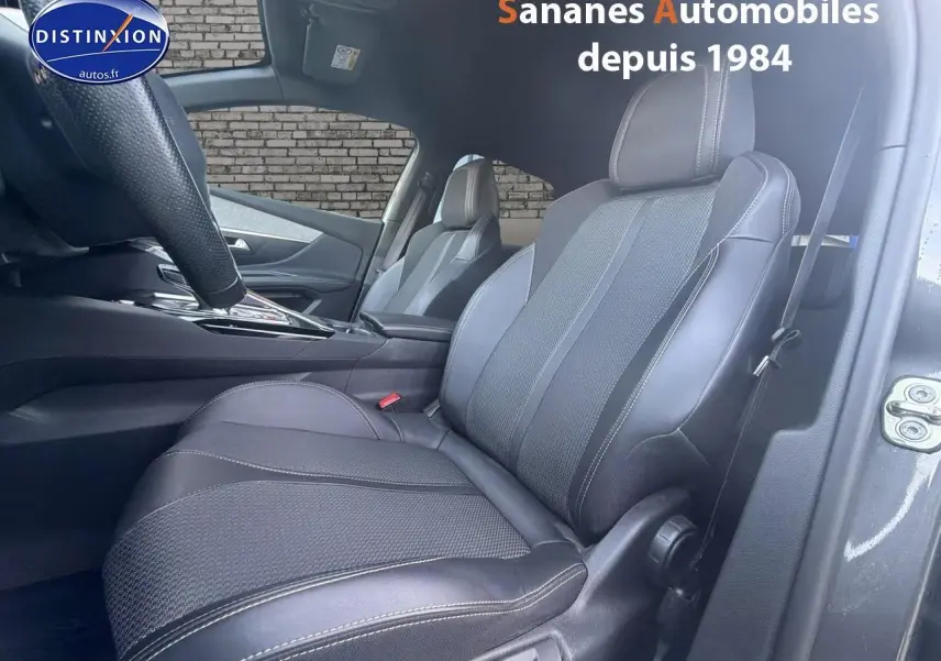 Vue intérieure côté conducteur du Peugeot 3008 gris foncé, mettant en valeur les sièges en cuir noir avec surpiqûres contrastées.