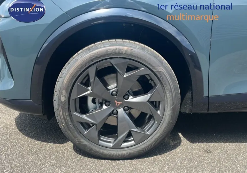 Gros plan sur la roue avant gauche du CUPRA Formentor bleu Fjord Metal avec jante noire au design anguleux.