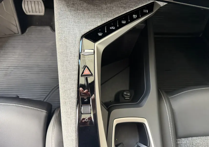 Vue plongeante sur la console centrale intérieure du Peugeot 1007 gris artense, avec commandes tactiles et tissu clair.
