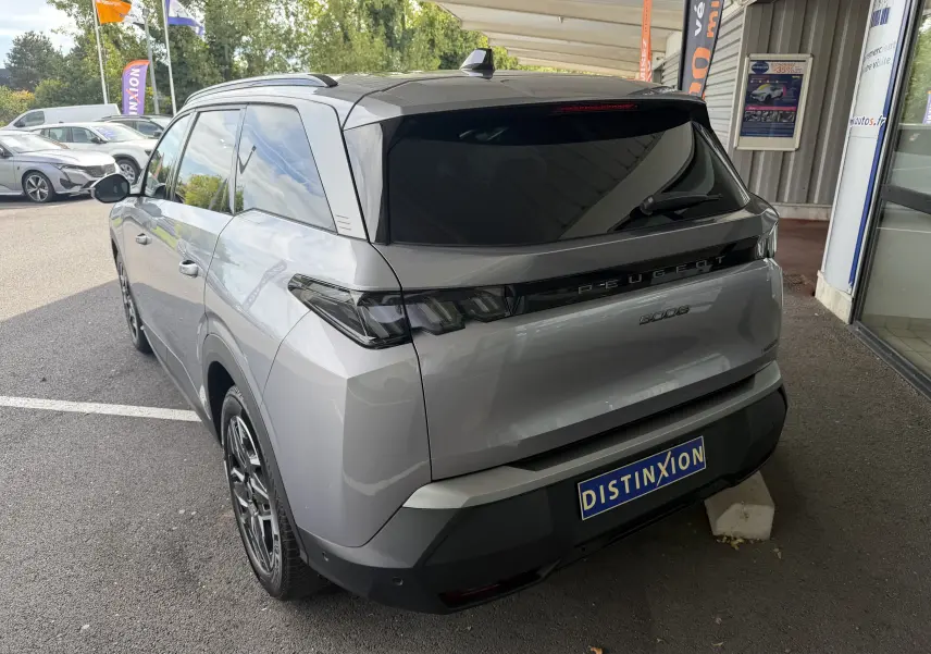Vue 3/4 arrière droite d’un Peugeot 5008 gris artense avec vitres teintées et jantes alliage noir.